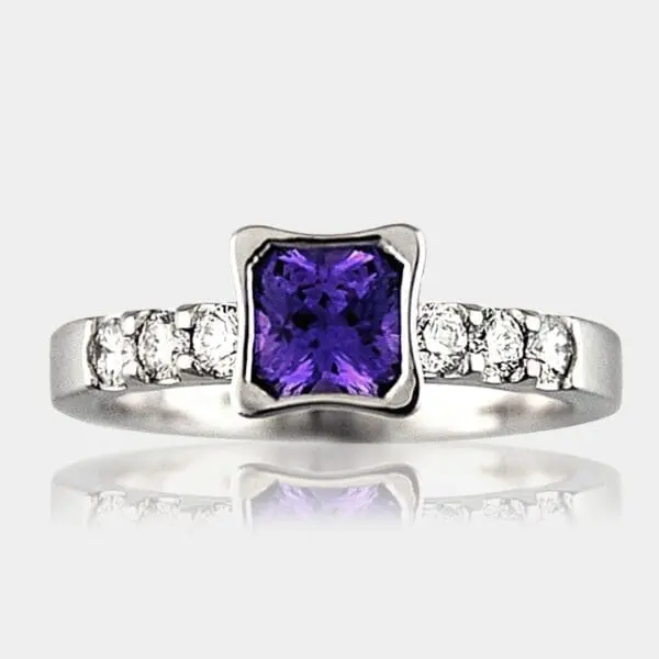 Radiant cut purple sapphire ring with diamond shoulder stones.