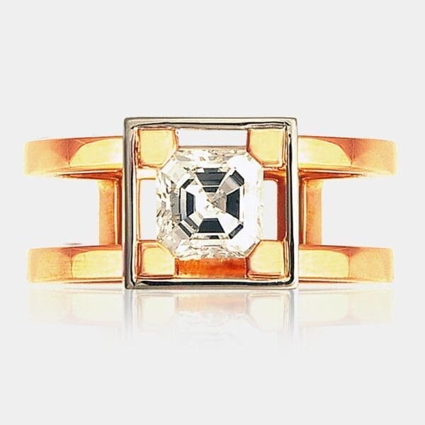 Handmade, contemporary style engagement ring featuring picture-frame set Asscher cut diamond with split band in 18ct rose gold.