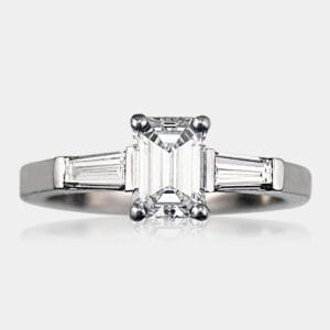 Handmade three-stone emerald cut diamond engagement ring with tapered baguette diamonds in 18ct white gold.