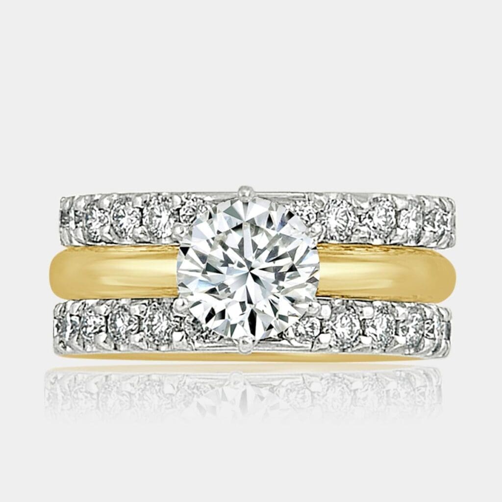 Round brilliant cut engagement and pair of gold wedding rings.