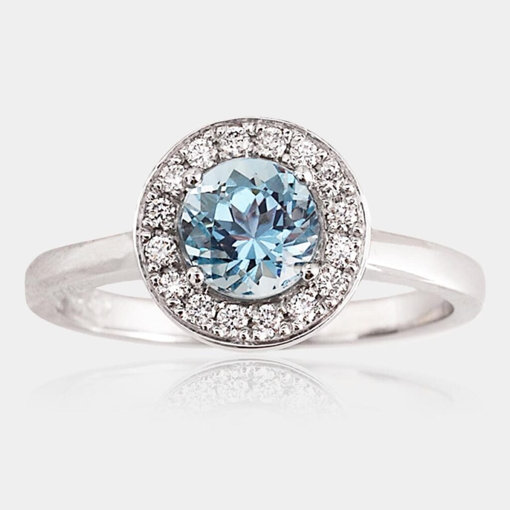 Handmade, 18ct white gold halo engagement ring or fashion ring featuring a stunning blue aquamarine and bead set halo of round brilliant cut diamonds.