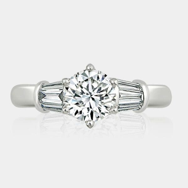 Round brilliant cut diamond engagement ring with 6 large tapered baguette shoulder diamonds.