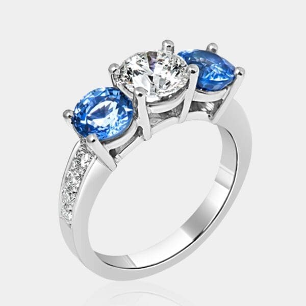 Handmade 18ct white gold ring featuring blue ceylon sapphires and round brilliant cut diamond with bead set diamonds in the band.
