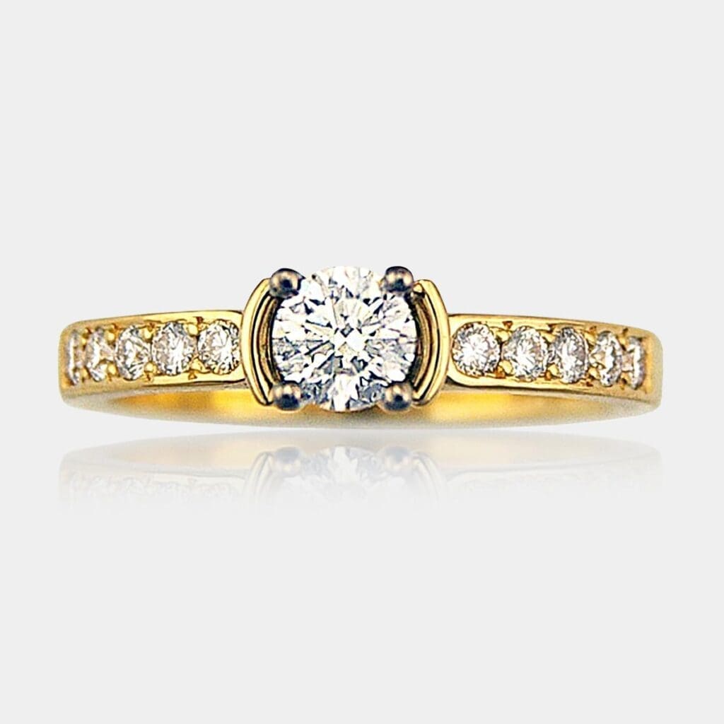 Handmade round brilliant cut diamond engagement ring with 18ct white gold four claw seting and bead set diamonds in 18ct yellow gold band.