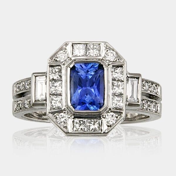 Handmade, radiant cut blue sapphire engagement ring with baguette and princess cut diamonds. 18ct white gold double row band set with round brilliant cut diamonds.