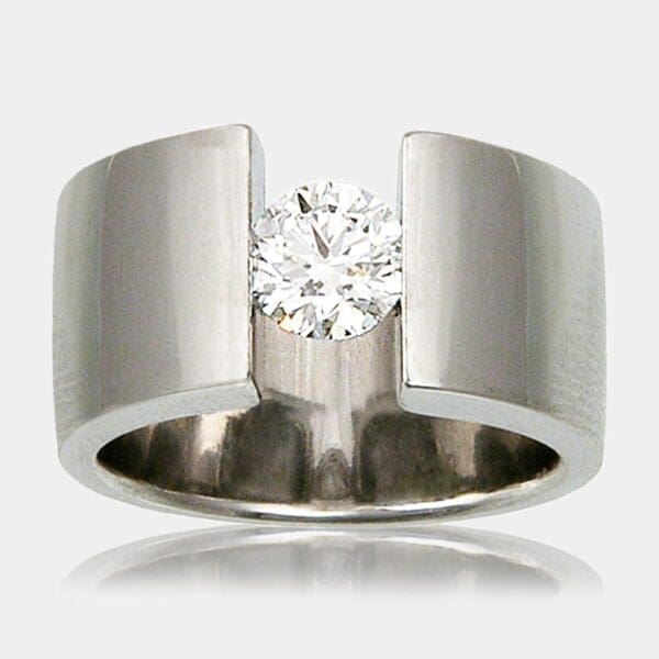 0.80ct round brilliant cut diamond ring tension set in 10mm wide 18ct gold band.