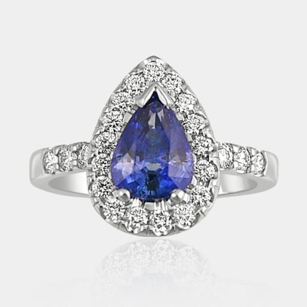 Pear shape blue sapphire with round brilliant cut diamond halo and matching diamonds in the shoulders.