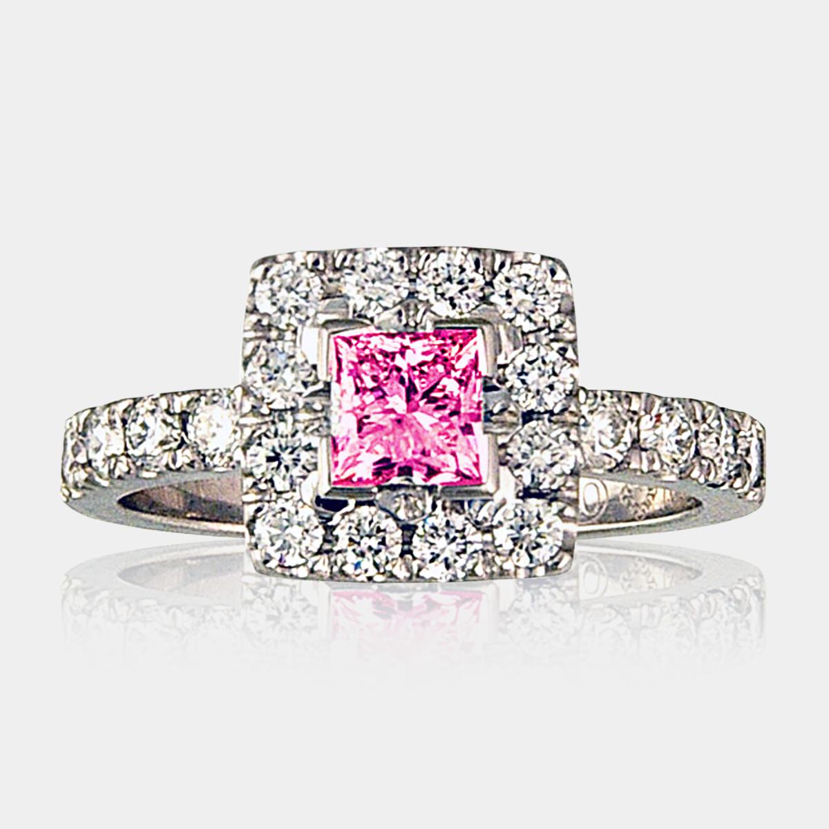 Pink princess cut sapphire engagement ring with round brilliant cut diamond halo and round diamonds in the band.