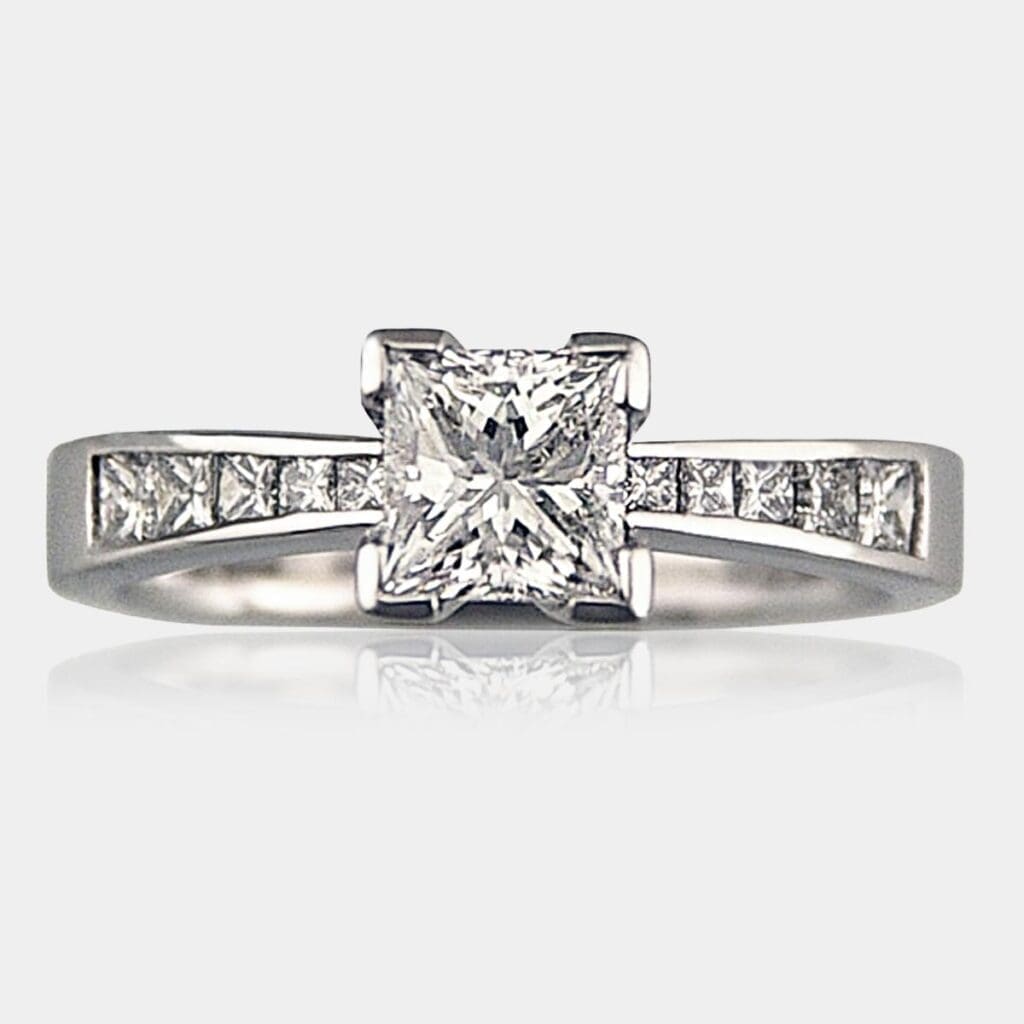 Handmade princess cut diamond engagement ring with graduated princess cut shoulder diamonds in 18ct white gold.
