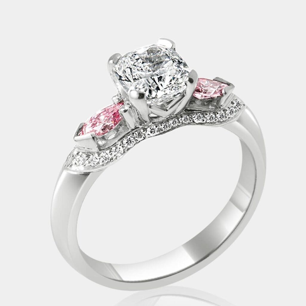 Handmade, designer style engagement ring with cushion cut diamond in the centre, featuring pear shape pink diamonds and round diamonds surrounding and underneath main setting in 18ct white gold.