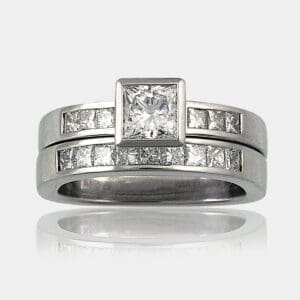 0.53 carat centre diamond with princess cut shoulder diamonds in 18ct white gold with matching princess cut diamond wedding ring.