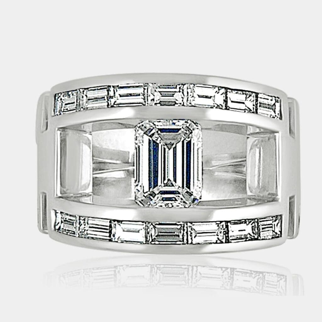 Diamond dress ring featuring tension set Emerald cut diamond and two rows of channel set baguette diamonds in a wide, split shank.