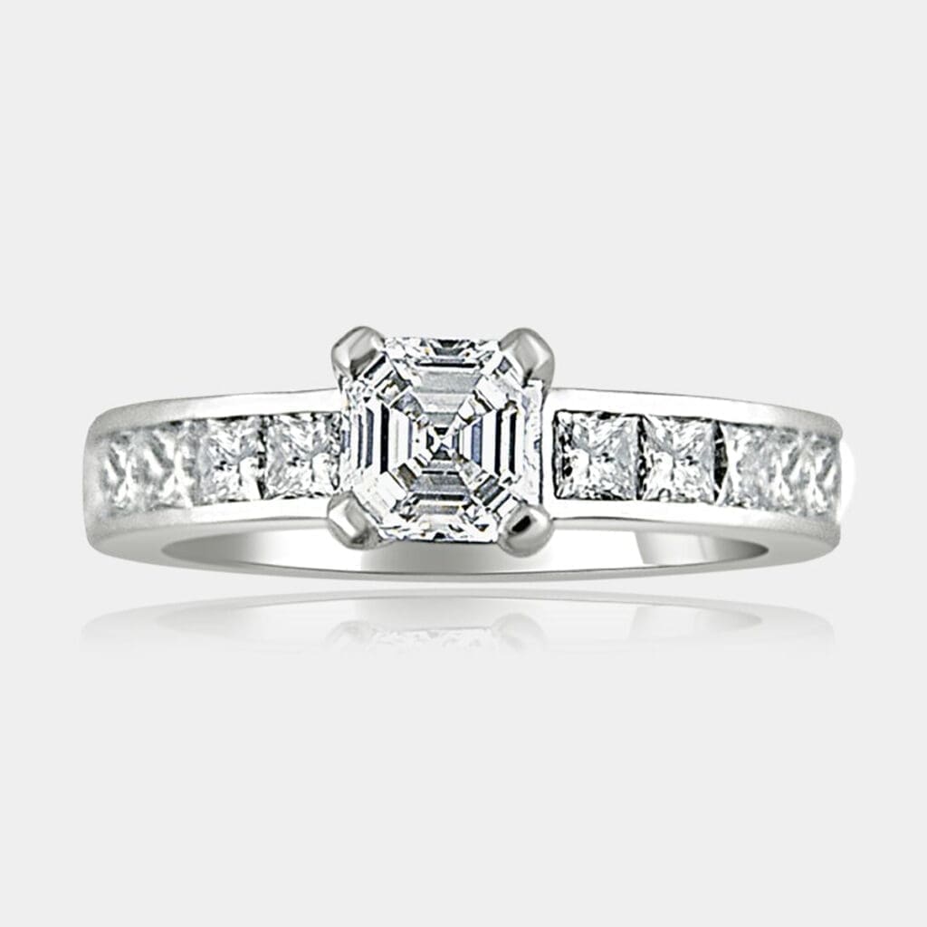 Asscher cut diamond ring with large princess cut shoulder diamonds set in white gold.