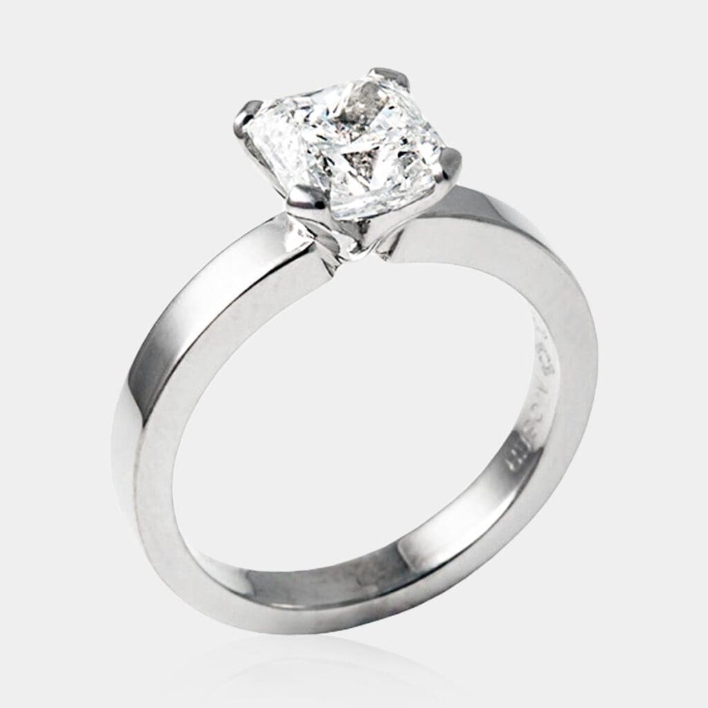 Handmade, radiant cut solitaire diamond engagement ring with a flat band in 18ct white gold.