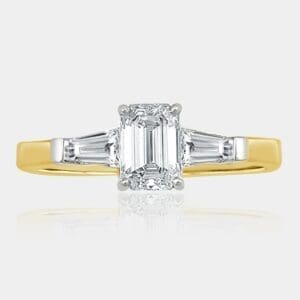 Handmade three-stone ring with emerald cut diamond and tapered baguettes in 18ct white gold setting and 18ct yellow gold band.