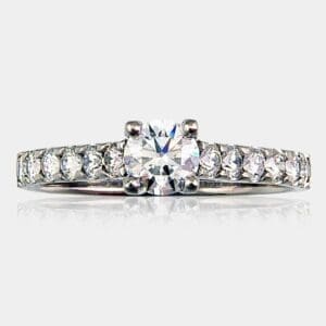 Handmade round brilliant cut diamond engagement with shared claw shoulder diamonds.
