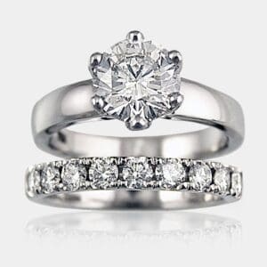 Round brilliant cut diamond engagement ring in white gold with matching diamond wedding ring.