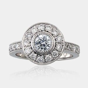 0.45 carat Round brilliant cut diamond halo ring with round shoulder diamonds and milgrain detail.