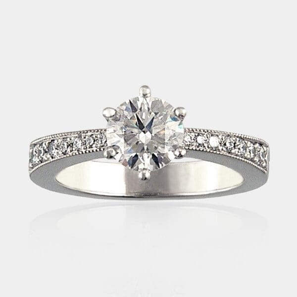 0.85 carat Round brilliant cut diamond ring with shoulder diamonds in a tapered, milgrain band.