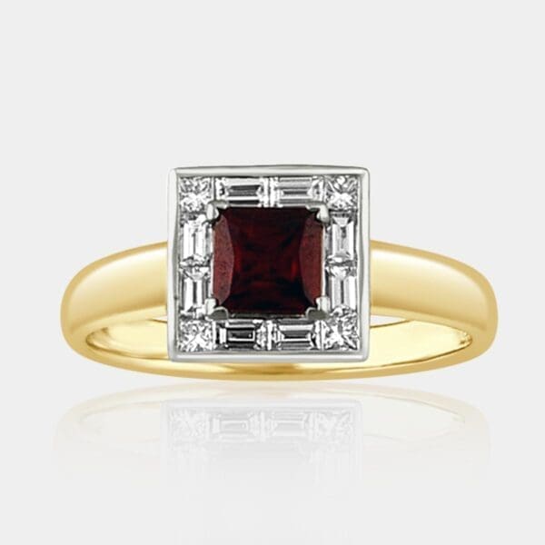 Two-tone gold ring featuring princess cut ruby with square halo of surrounding princess cut diamonds and baguette cut diamonds.