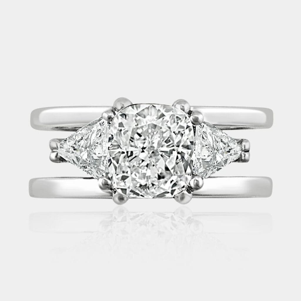 1.60 carat Cushion cut diamond ring with trilliant cut diamonds on each side.