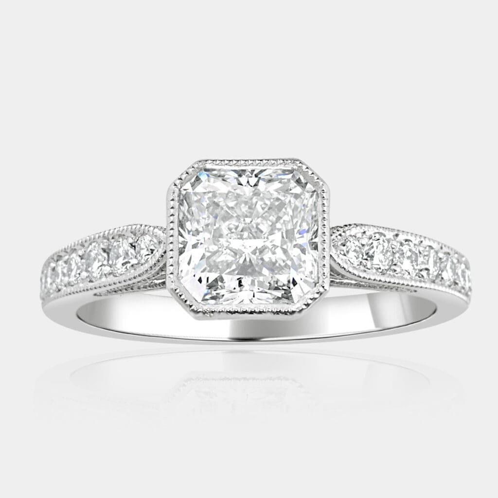 Octagol shape, designer ring featuring cut-cornered princess cut diamond with bead set round brilliant cut diamonds in the band and milgrain detail.