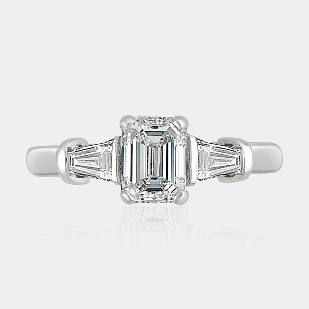 1.01 carat D-VS grade emerald cut diamond engagement ring with large tapered baguette shoulder diamonds.