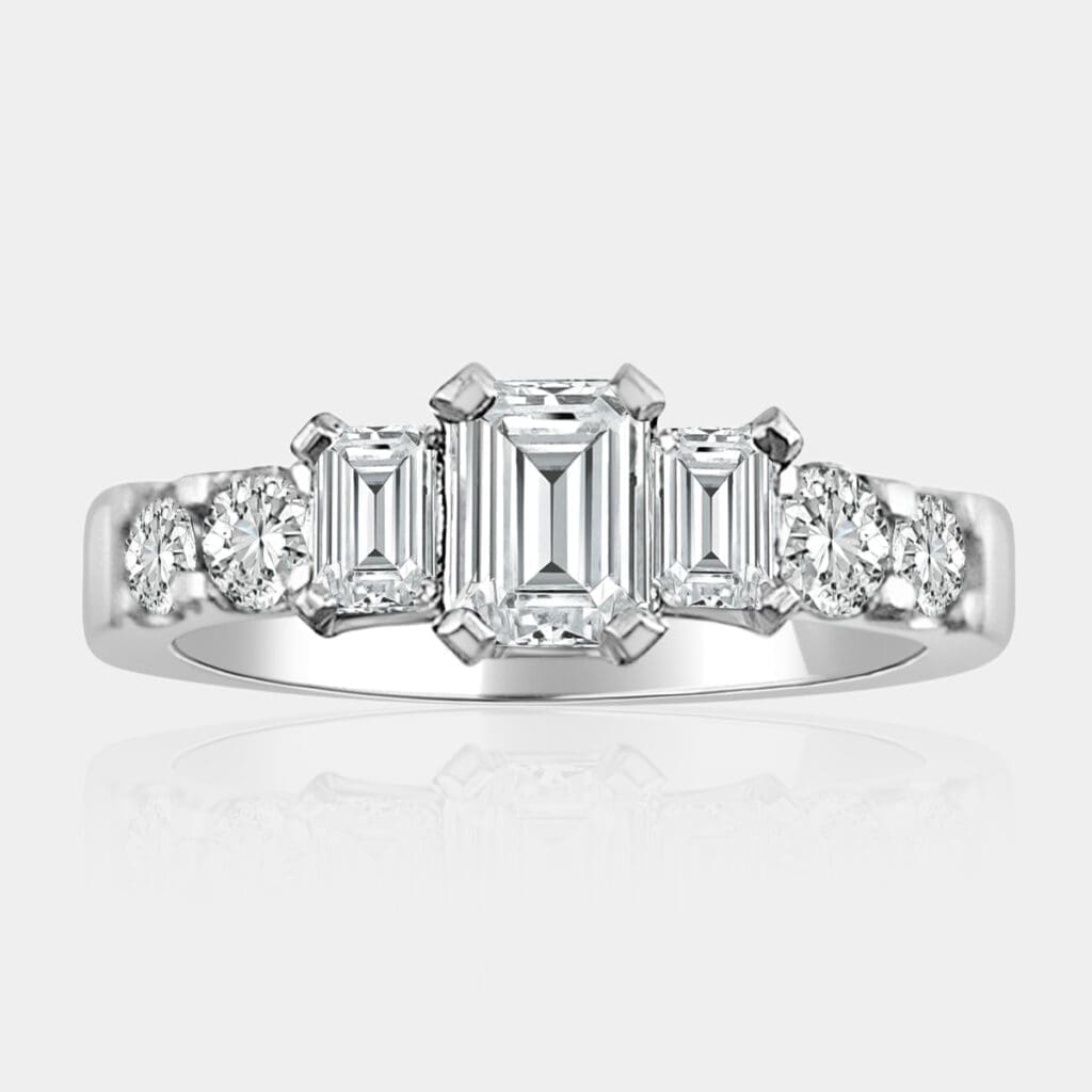 3 stone emerald cut diamond ring with round brilliant cut shoulder diamonds and matching diamond wedding band.