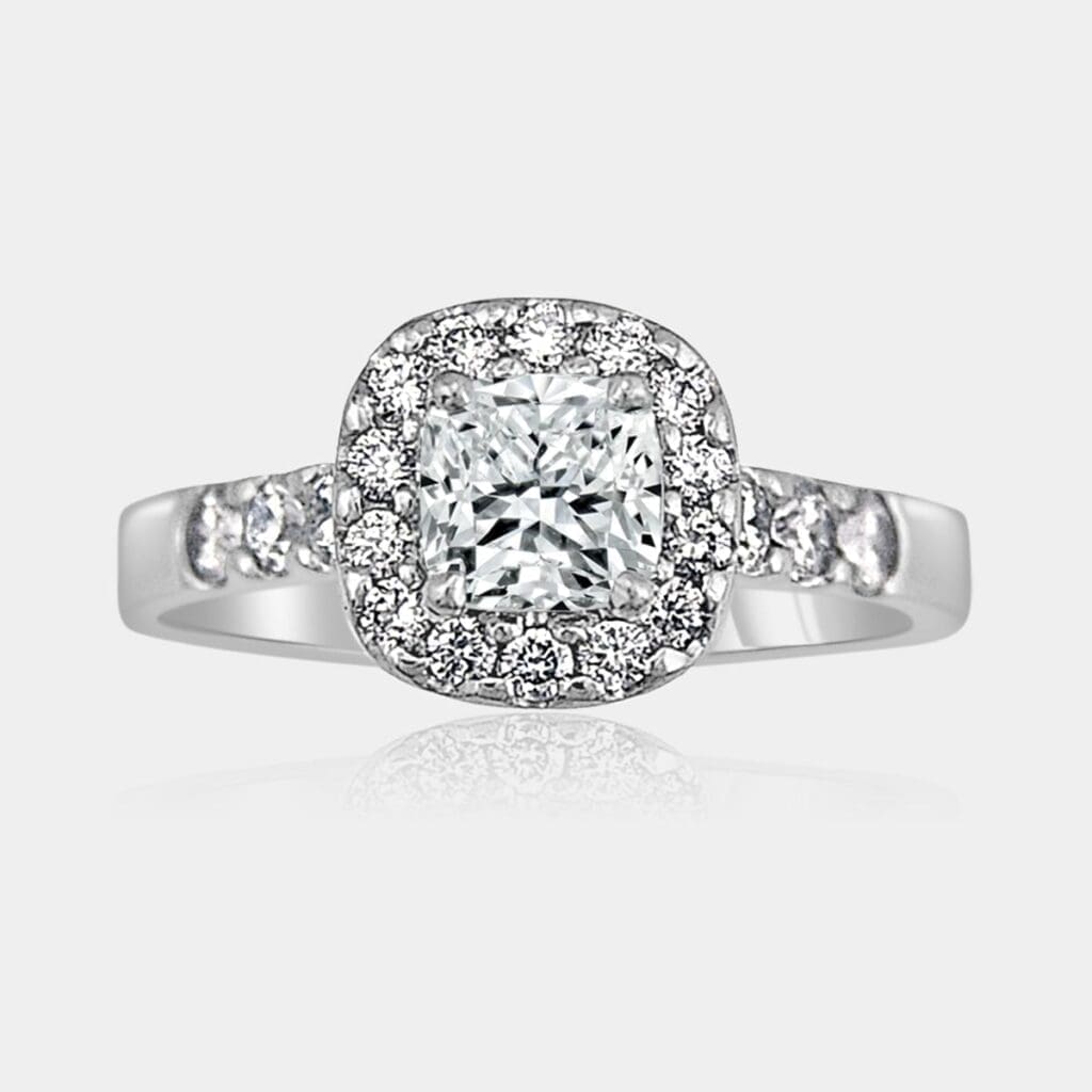 Handmade 18ct white gold, cushion cut diamond engagement ring with a halo of round diamonds and diamonds in the band.