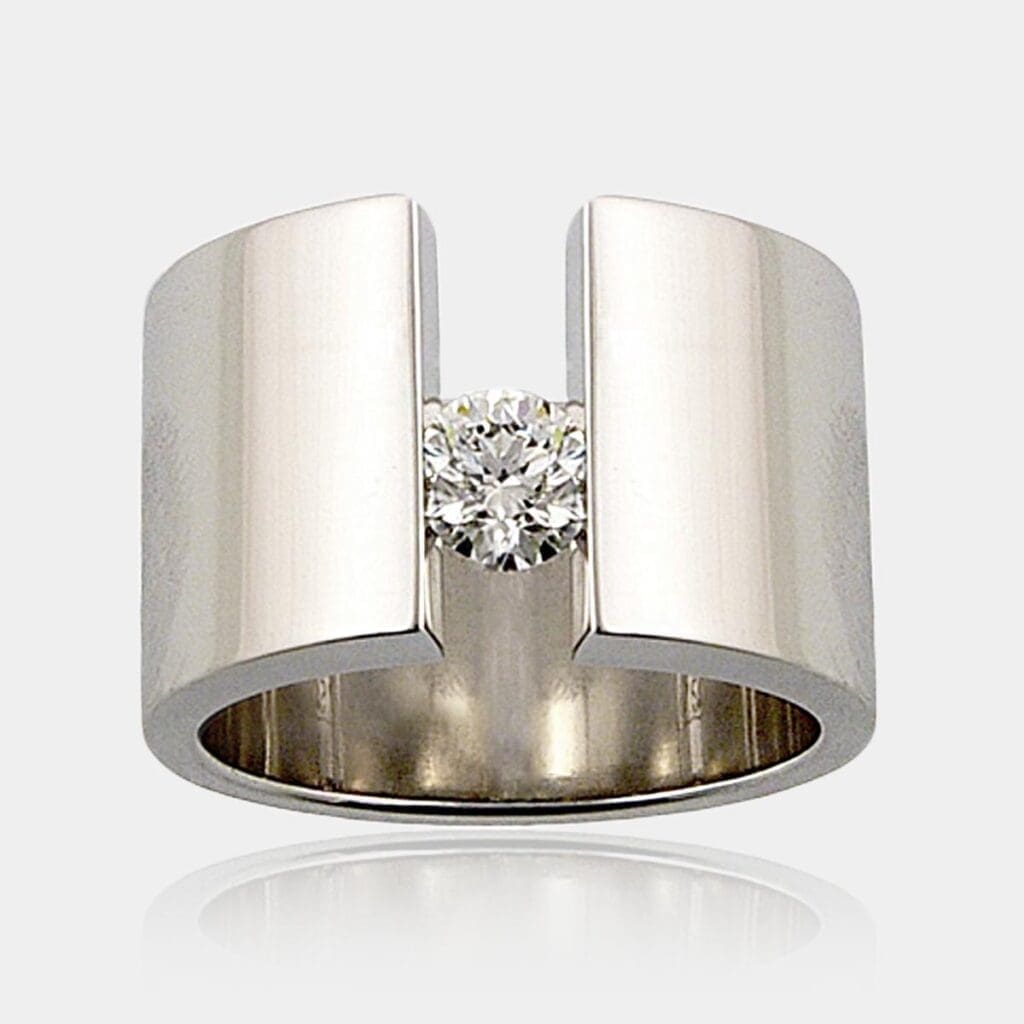0.40ct round brilliant cut diamond ring tension set in 16mm wide 18ct gold band.