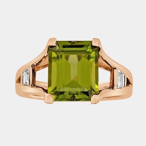 Fashion ring featuring emerald cut peridot and trapezoid cut diamonds suspended in the band.