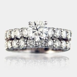 Round brilliant cut engagement ring with share claw shoulder diamonds.