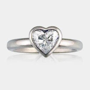Heart shape diamond ring in a bezel setting and rounded band.