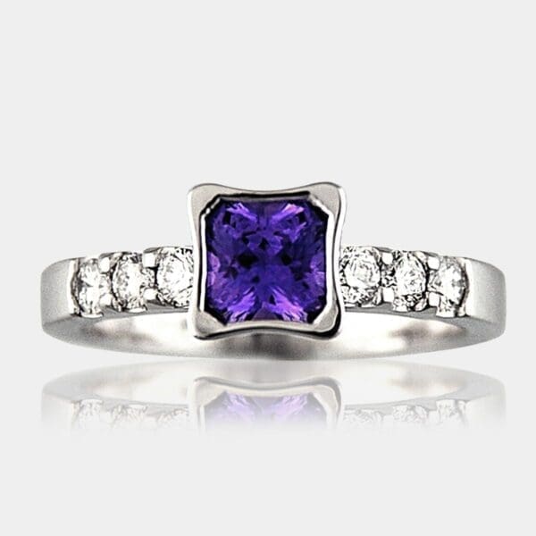 Radiant cut purple sapphire ring with diamond shoulder stones.