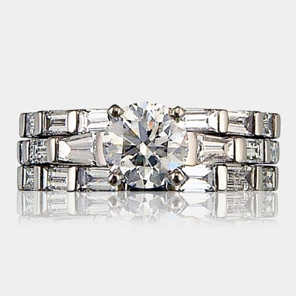Round brilliant cut diamond engagement ring with baguette cut diamonds and matching wedding and eternity ring.