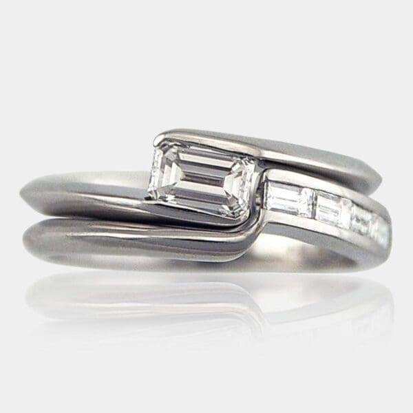 Emerald cut diamond engagement ring with matching, fitted wedding ring set with baguette diamonds.