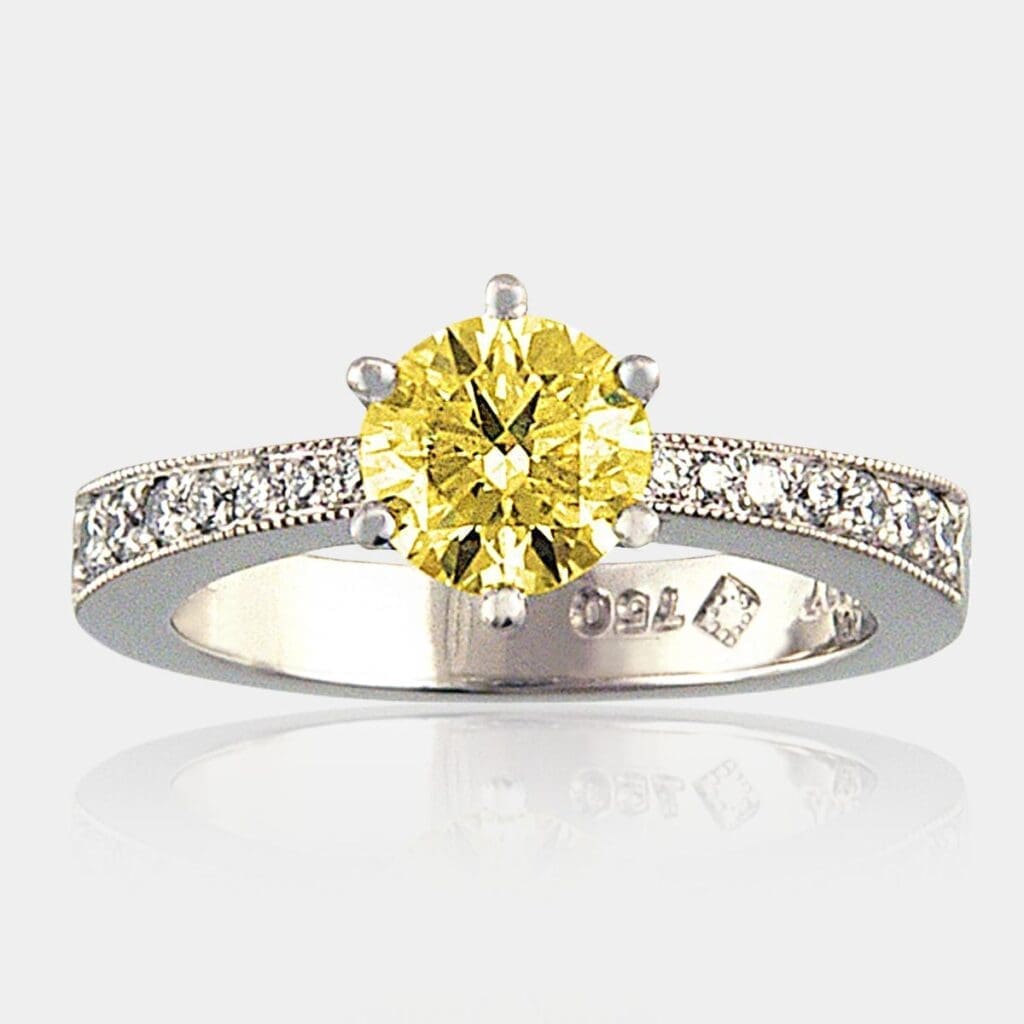 0.85 carat Round yellow diamond ring with bead set shoulder diamonds in a tapered band with milgrain finish.